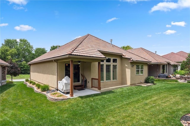 1415 SW Antiquity Dr, Lees Summit, MO 64081 - back of property featuring ceiling fan, a tiled roof, a yard, and stucco siding