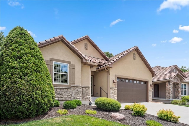 1415 SW Antiquity Dr, Lees Summit, MO 64081 - view of front of house featuring stone siding, an attached garage, stucco siding, concrete driveway, and a tile roof