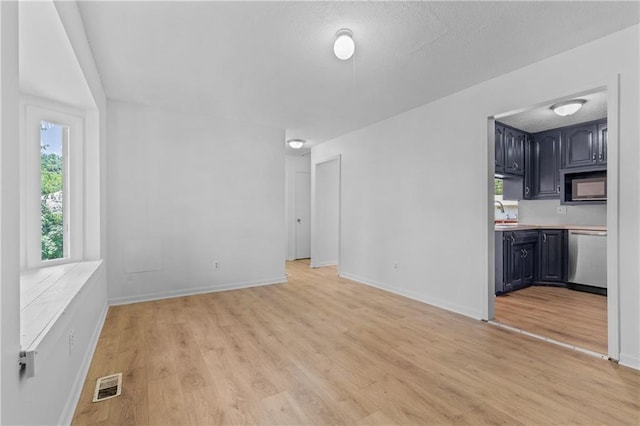 600 W Powahatan Ct, Independence, MO 64056 - unfurnished living room with light wood-style floors and baseboards