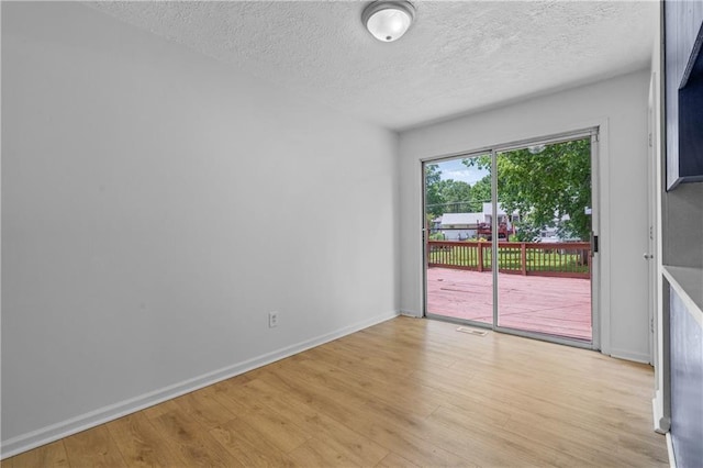 600 W Powahatan Ct, Independence, MO 64056 - empty room with a textured ceiling and light wood-style flooring