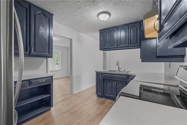 600 W Powahatan Ct, Independence, MO 64056 - kitchen with stainless steel fridge, light countertops, light wood-style floors, a textured ceiling, and open shelves