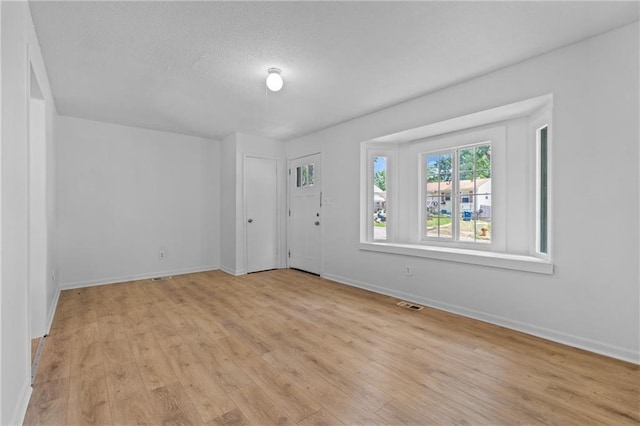 600 W Powahatan Ct, Independence, MO 64056 - spare room featuring light wood-style flooring and a textured ceiling