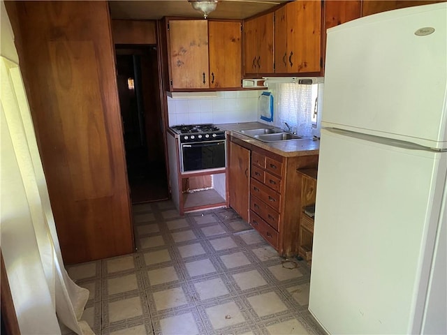 39055 Railroad Ave, Osawatomie, KS 66064 - kitchen with freestanding refrigerator, light flooring, brown cabinets, decorative backsplash, and oven