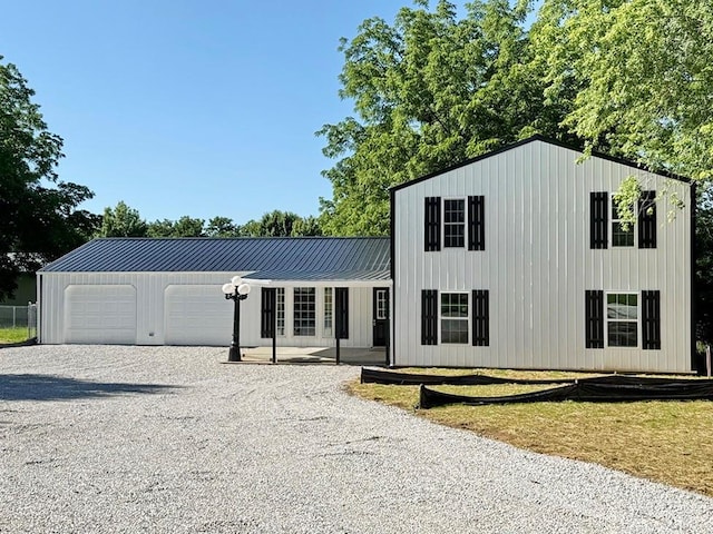 622 Morgan Dr, Stockton, MO 65785 - view of front of home featuring gravel driveway, a metal roof, and a garage