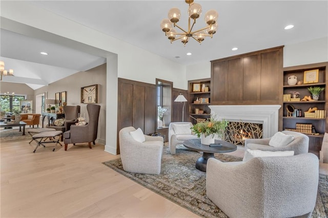 12811 W 71st St, Shawnee, KS 66216 - living room with a chandelier, light wood-style floors, a lit fireplace, and recessed lighting