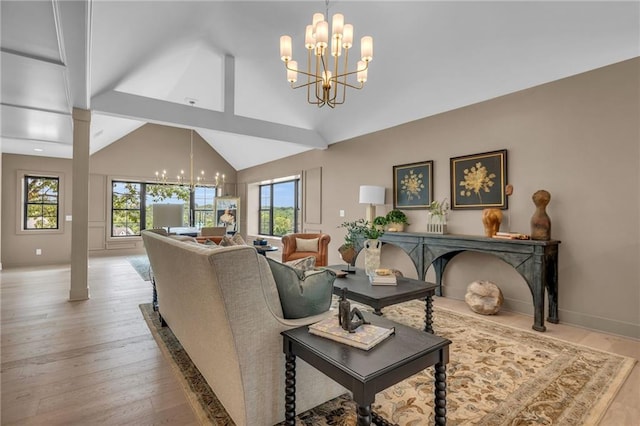 12811 W 71st St, Shawnee, KS 66216 - living area featuring a chandelier, wood finished floors, plenty of natural light, ornate columns, and high vaulted ceiling