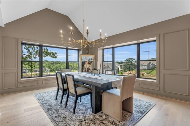 12811 W 71st St, Shawnee, KS 66216 - dining space with a chandelier, high vaulted ceiling, and light wood-style flooring