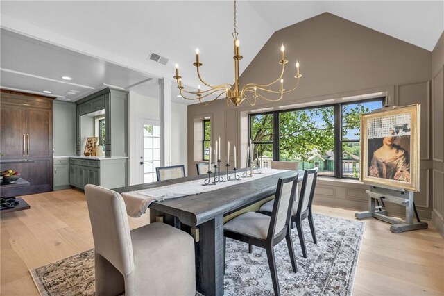 12811 W 71st St, Shawnee, KS 66216 - dining room featuring a chandelier, light wood finished floors, recessed lighting, and high vaulted ceiling