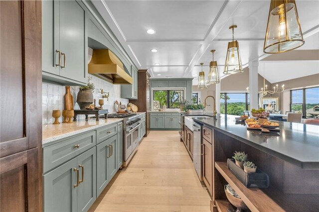 12811 W 71st St, Shawnee, KS 66216 - kitchen featuring stainless steel range, custom exhaust hood, light wood finished floors, a chandelier, and plenty of natural light