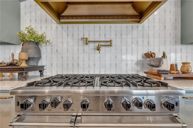 12811 W 71st St, Shawnee, KS 66216 - detailed view of high end stainless steel range oven, pot filler, decorative backsplash, custom range hood, and light stone counters