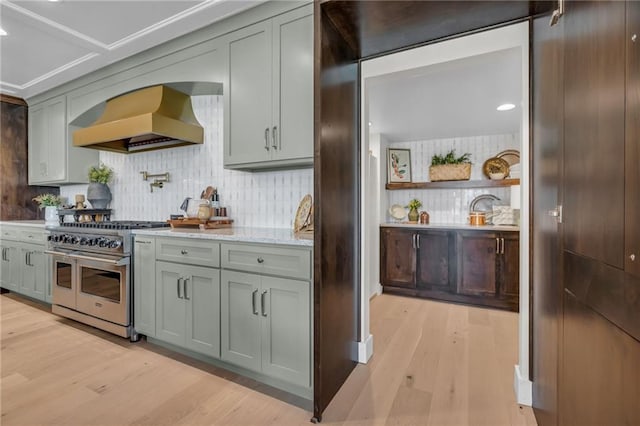 12811 W 71st St, Shawnee, KS 66216 - kitchen with range with two ovens, premium range hood, decorative backsplash, light wood-style floors, and recessed lighting