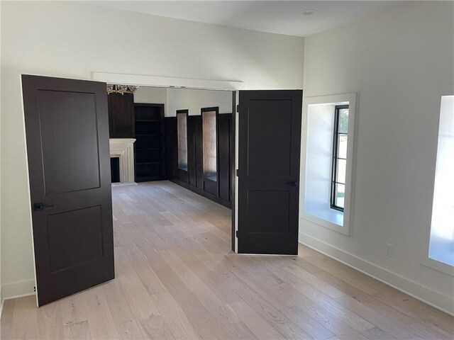 12811 W 71st St, Shawnee, KS 66216 - spare room with light wood finished floors, a chandelier, and a fireplace