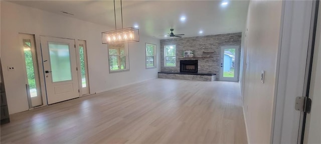 104 Lakeshore Dr, Kimberling City, MO 65686 - unfurnished living room with light wood-type flooring, a stone fireplace, healthy amount of natural light, and a ceiling fan