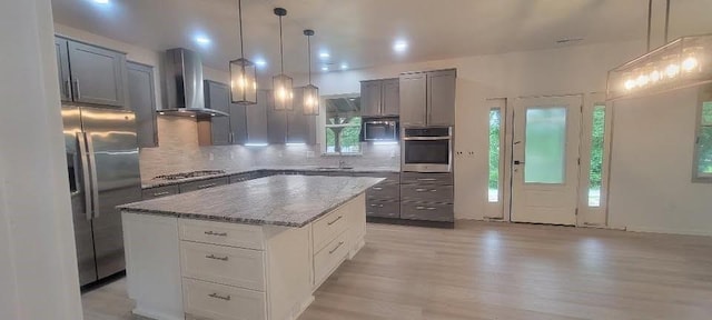 104 Lakeshore Dr, Kimberling City, MO 65686 - kitchen with appliances with stainless steel finishes, wall chimney exhaust hood, decorative backsplash, and light wood-style flooring