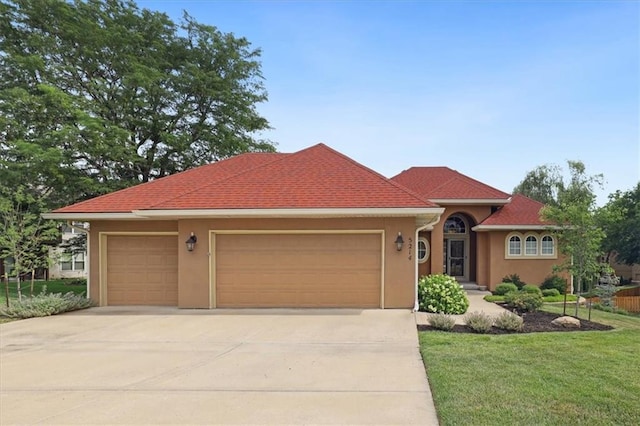 5214 NE 70th St, Kansas City, MO 64199 - view of front of property with concrete driveway, an attached garage, a front yard, and stucco siding