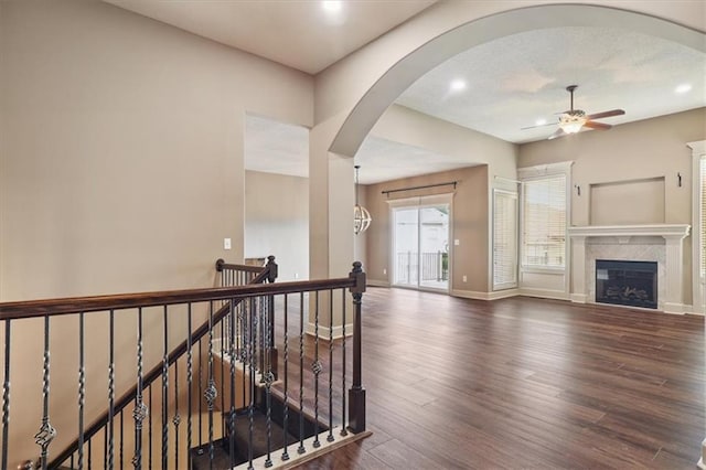 5214 NE 70th St, Kansas City, MO 64199 - hallway featuring wood finished floors, an upstairs landing, recessed lighting, and arched walkways