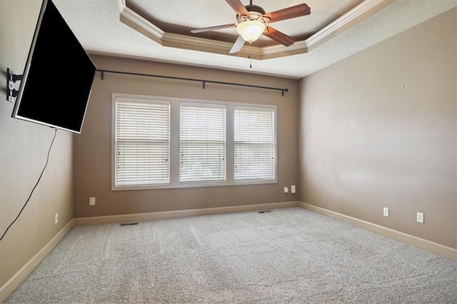 5214 NE 70th St, Kansas City, MO 64199 - spare room featuring a tray ceiling, ornamental molding, a ceiling fan, and carpet flooring