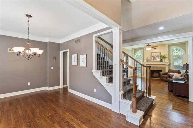 16369 S Woodstone Dr, Olathe, KS 66062 - staircase featuring a chandelier, a ceiling fan, ornamental molding, a tile fireplace, and wood finished floors
