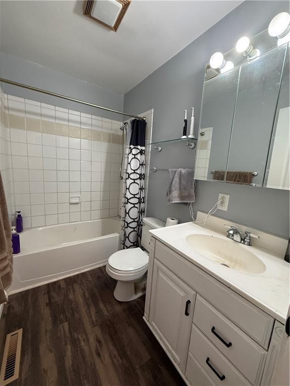 913 N Pine St, Cameron, MO 64429 - full bath featuring vanity, shower / bathtub combination with curtain, and wood finished floors