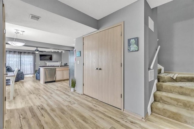 4540 NE 83rd Ter, Kansas City, MO 64119 - kitchen with open floor plan, stainless steel dishwasher, light wood-style flooring, a ceiling fan, and light brown cabinets