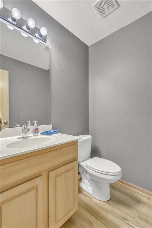 4540 NE 83rd Ter, Kansas City, MO 64119 - half bath featuring wood finished floors, vanity, and a textured ceiling