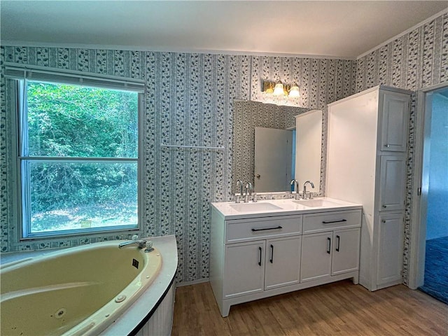 122 Fairway Dr, Mound City, KS 66056 - bathroom featuring wallpapered walls, wood finished floors, double vanity, and a whirlpool tub
