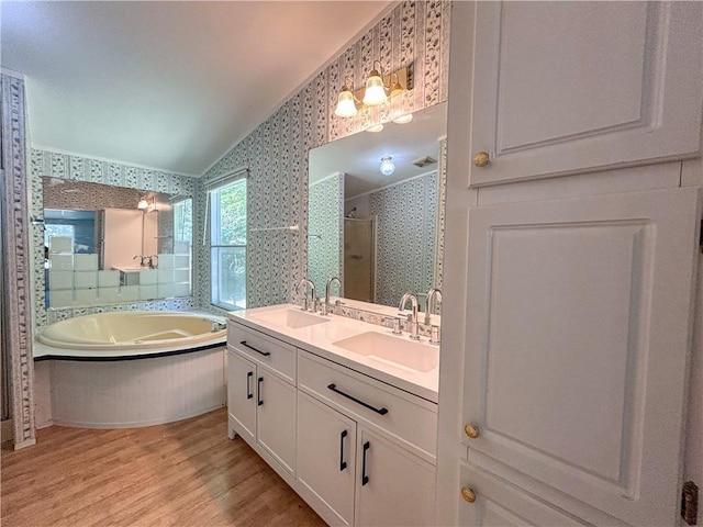 122 Fairway Dr, Mound City, KS 66056 - bathroom with wallpapered walls, a stall shower, a garden tub, wood finished floors, and double vanity