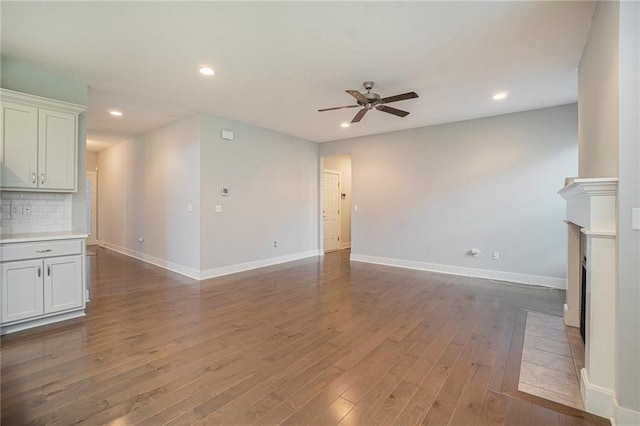 14446 Houston St, Olathe, KS 66061 - unfurnished living room with ceiling fan, wood finished floors, a fireplace with flush hearth, and recessed lighting