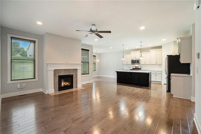 14446 Houston St, Olathe, KS 66061 - unfurnished living room with a ceiling fan, dark wood-style floors, a fireplace, and recessed lighting