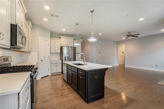 14446 Houston St, Olathe, KS 66061 - kitchen with appliances with stainless steel finishes, light countertops, ceiling fan, wood finished floors, and tasteful backsplash