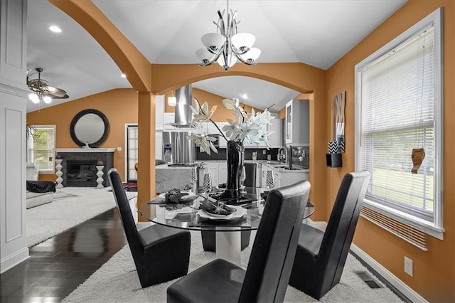 7103 E 159th St, Belton, MO 64012 - dining area featuring lofted ceiling, a glass covered fireplace, arched walkways, a chandelier, and wood finished floors