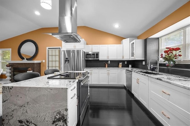 7103 E 159th St, Belton, MO 64012 - kitchen with appliances with stainless steel finishes, island exhaust hood, vaulted ceiling, decorative backsplash, and white cabinetry