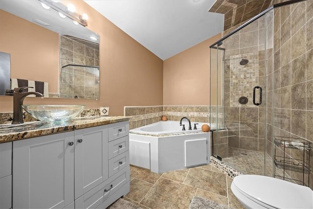 7103 E 159th St, Belton, MO 64012 - bathroom with vanity, a bath, a stall shower, vaulted ceiling, and stone finish flooring