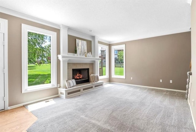 14155 W 147th Ter, Olathe, KS 66062 - unfurnished living room featuring crown molding, a textured ceiling, a tiled fireplace, and carpet flooring