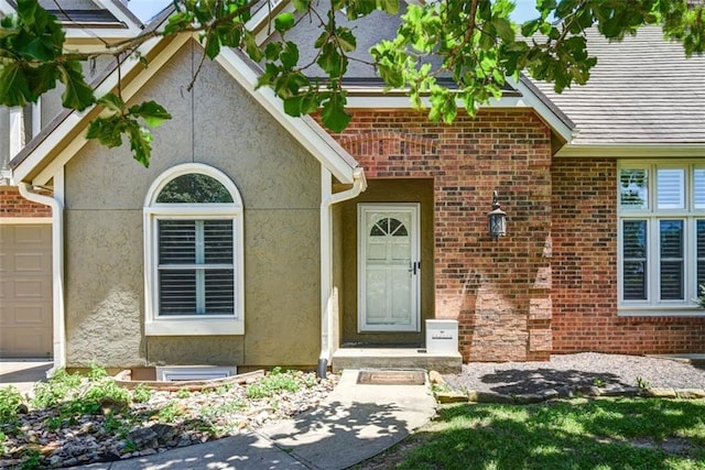 3147 N 131st St, Kansas City, KS 66109 - doorway to property with stucco siding, brick siding, and an attached garage