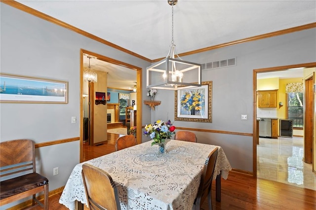 11808 W 128th St, Overland Park, KS 66213 - dining area featuring a chandelier, crown molding, and wood finished floors