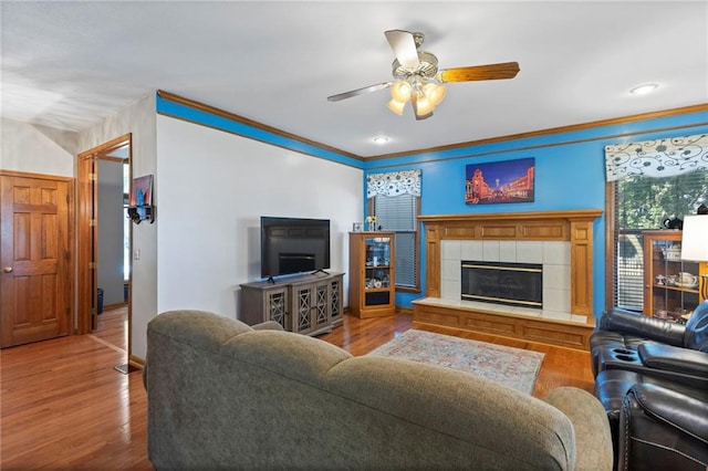 11808 W 128th St, Overland Park, KS 66213 - living area featuring ceiling fan, wood finished floors, a tile fireplace, and crown molding