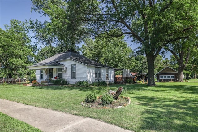 311 E Mary St, Yates Center, KS 66783 - view of front facade featuring a front yard, an AC wall unit, and covered porch
