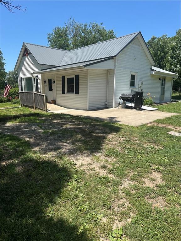 317 Chrissenger St, Burlington Junction, MO 64428 - back of house with a yard, a metal roof, and a patio area