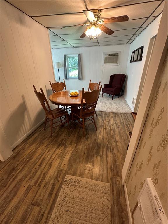 317 Chrissenger St, Burlington Junction, MO 64428 - dining space with dark wood-style flooring, a ceiling fan, and an AC wall unit