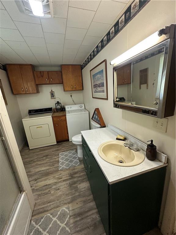 317 Chrissenger St, Burlington Junction, MO 64428 - bathroom featuring vanity, wood finished floors, and independent washer and dryer