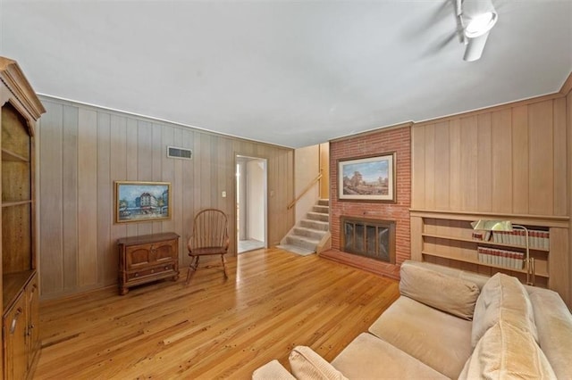 5211 W 79th Ter, Prairie Village, KS 66208 - living room featuring a fireplace, light wood-style floors, wooden walls, and stairs