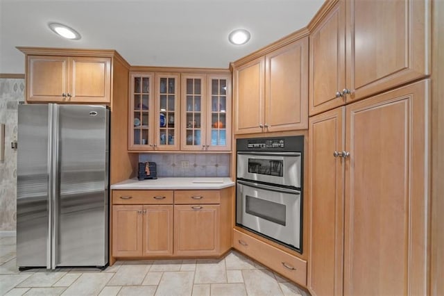 5211 W 79th Ter, Prairie Village, KS 66208 - kitchen with stainless steel appliances, light countertops, glass insert cabinets, backsplash, and brown cabinetry