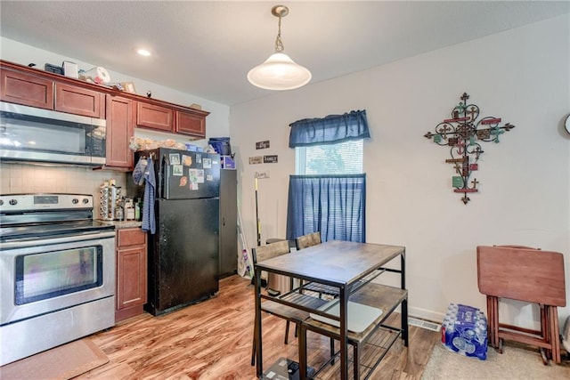 203 E Elm St, Olathe, KS 66061 - kitchen with stainless steel appliances, backsplash, light wood-type flooring, and hanging light fixtures