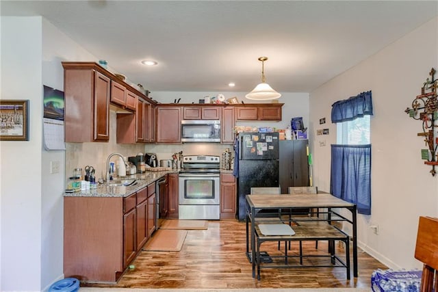 203 E Elm St, Olathe, KS 66061 - kitchen featuring stainless steel appliances, light wood-style flooring, pendant lighting, light stone countertops, and recessed lighting