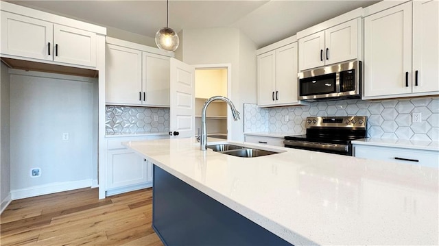 778 Creekmoor Dr, Raymore, MO 64083 - kitchen featuring stainless steel appliances, light countertops, light wood finished floors, decorative backsplash, and decorative light fixtures