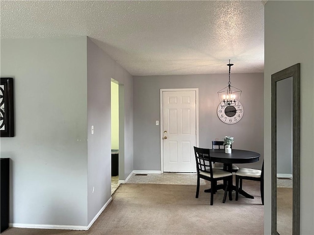 1423 Hickory St, Atchison, KS 66002 - carpeted dining room featuring a textured ceiling and a chandelier
