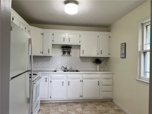 1423 Hickory St, Atchison, KS 66002 - kitchen featuring white appliances, backsplash, light countertops, white cabinetry, and a textured ceiling