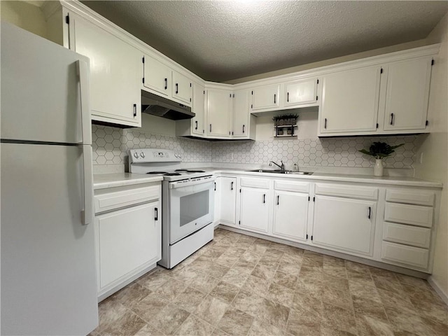 1423 Hickory St, Atchison, KS 66002 - kitchen with white appliances, under cabinet range hood, decorative backsplash, light countertops, and a textured ceiling
