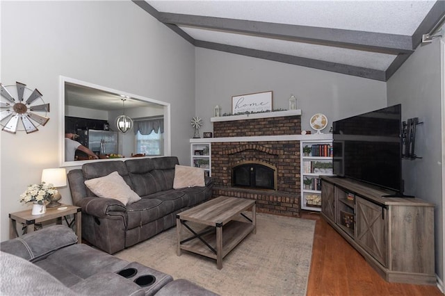 1005 SE Alice St, Blue Springs, MO 64014 - living area featuring wood finished floors, beamed ceiling, a fireplace, and high vaulted ceiling